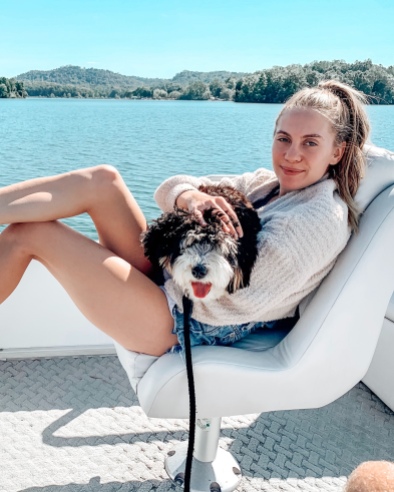 Image of Candace holding a dog on a boat in Tennessee.